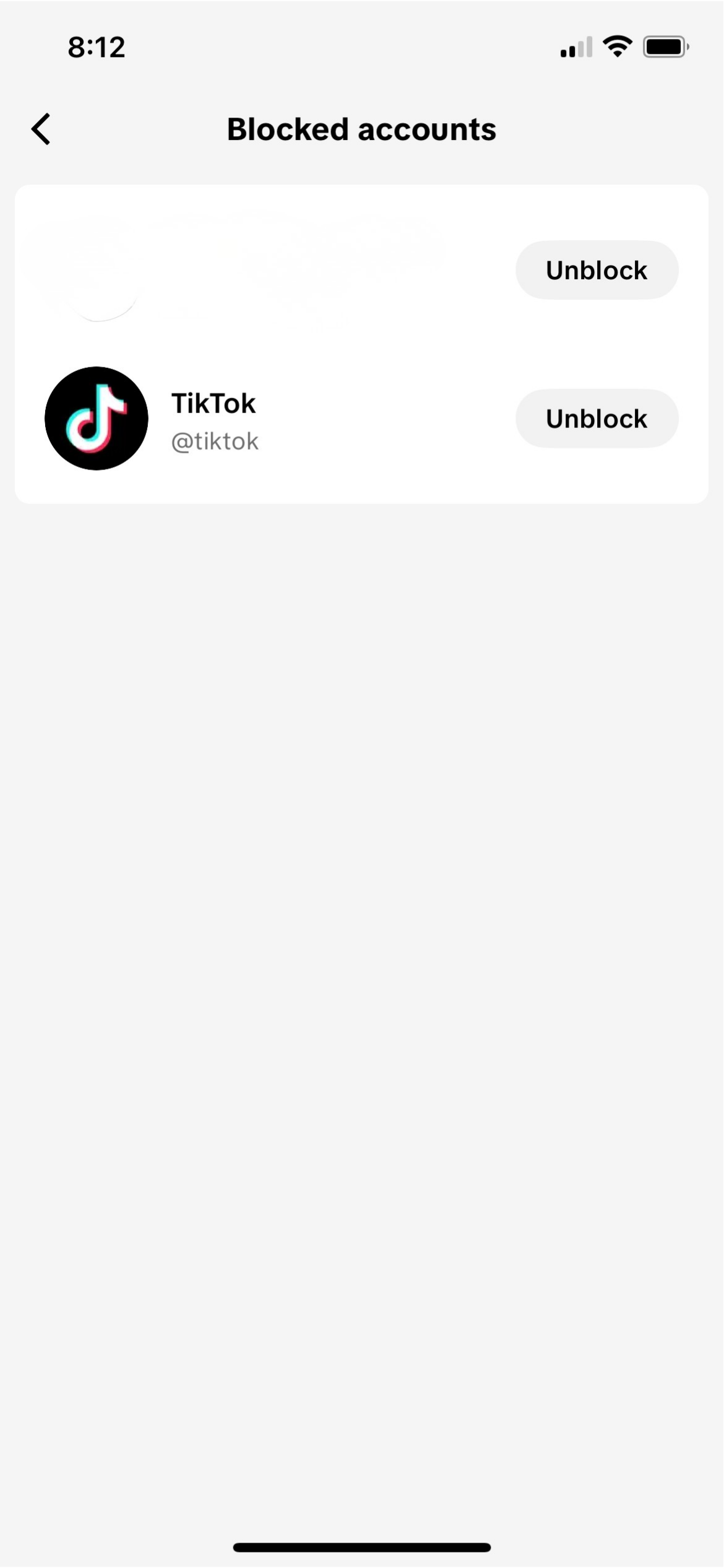 TikTok Blocked accounts screen on mobile showing TikTok account with Unblock button visible.
